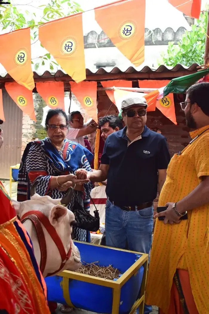 A visiting family placing fodder in the trough for Gau Mata